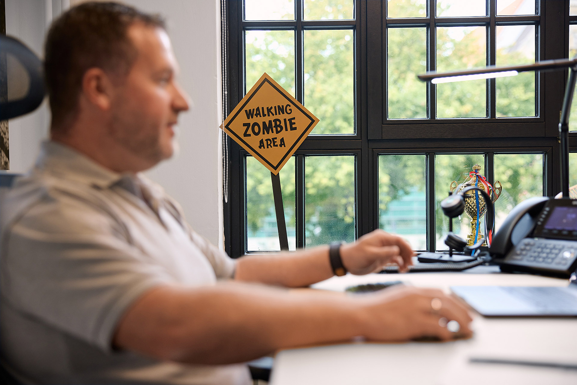 Ein humorvolles Detail im Büro von Kommunity Hannover: Ein „Walking Zombie Area“-Schild, das die lockere Arbeitskultur widerspiegelt. Authentische Unternehmensfotografie von Karsten Koch.