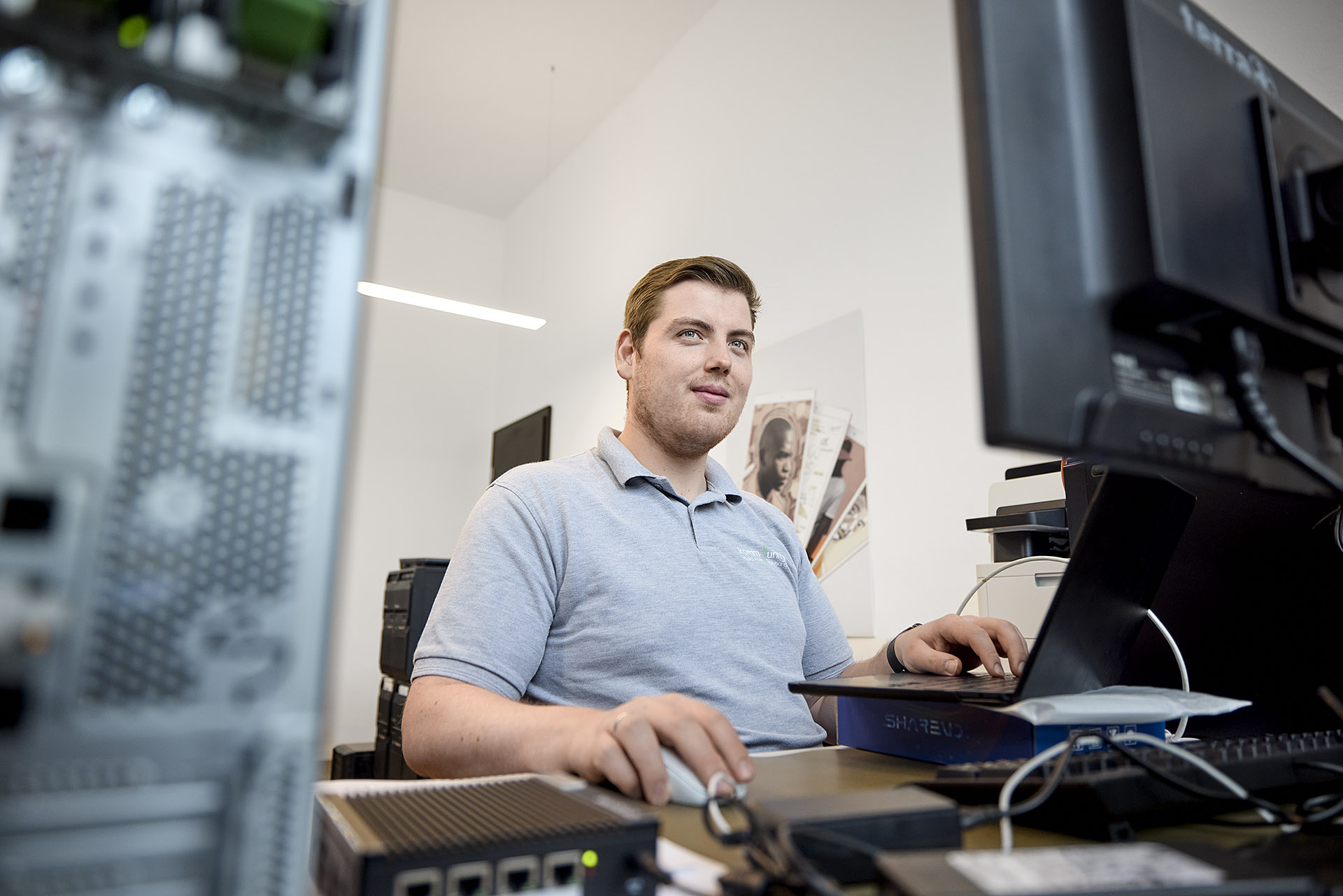 Kommunity Hannover Teammitglied bei der Arbeit an einem modernen Computerarbeitsplatz. Hochwertige Detailaufnahme von Karsten Koch für die Darstellung der technischen Infrastruktur und des Arbeitsumfelds im IT-Dienstleistungsbereich.