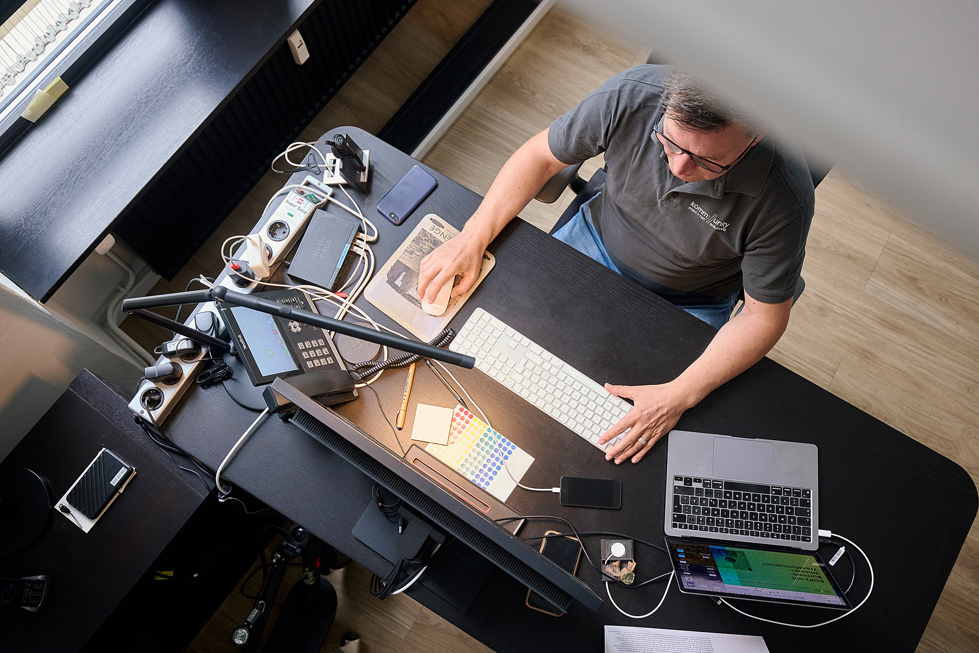 Porträt eines Mitarbeiters bei der Arbeit im Kommunity Büro in Hannover. Die Aufnahme von Karsten Koch fängt die Konzentration und Professionalität des Teams ein.