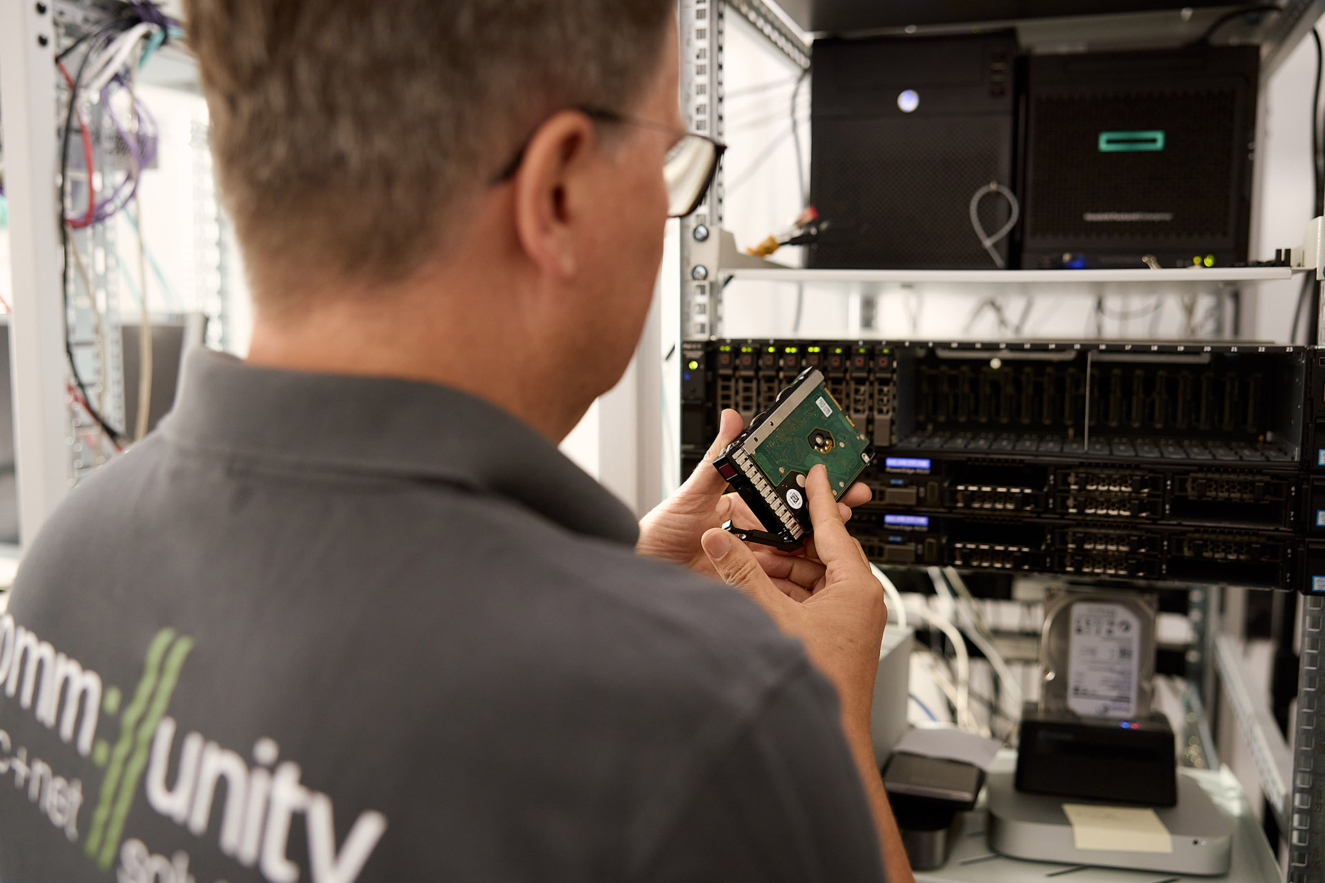 echniker von Kommunity Hannover beim Austausch einer Festplatte im Serverraum. Detailreiche Unternehmensfotografie von Karsten Koch für die Dokumentation technischer Serviceleistungen und IT-Infrastruktur, perfekt für Image- und Recruiting-Zwecke.