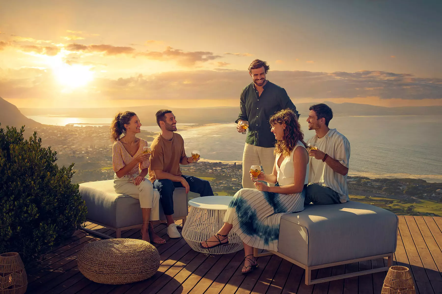 Eine Gruppe von Freunden geniesst Licor43 im Sonnenuntergang auf einer Bar Terrasse